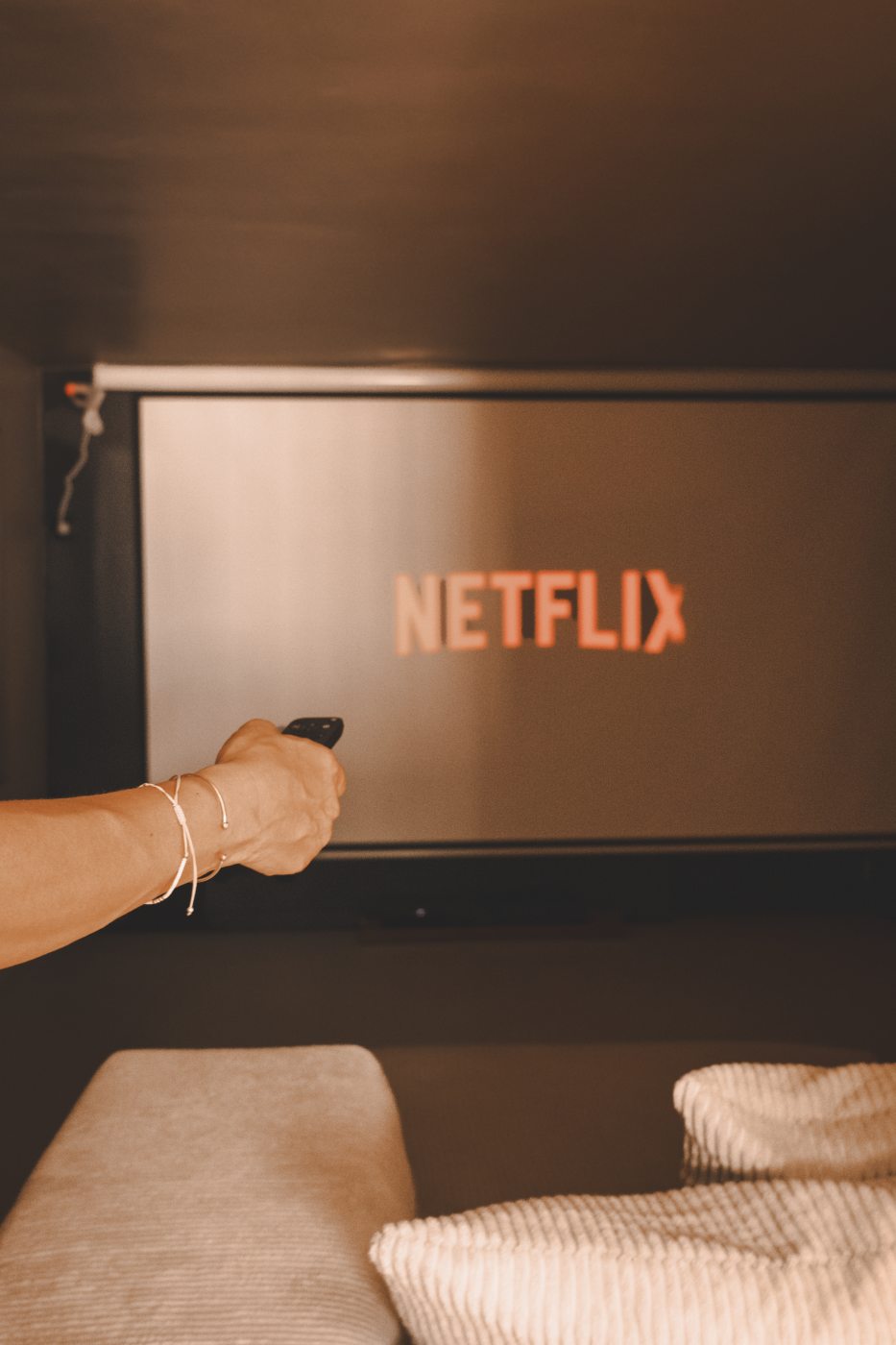 L'écran 4K de la salle de cinéma privative, télécommande en main